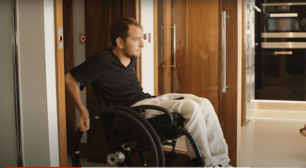 今は車椅子で生活しているホームズ（Crestron EMEA / YouTube）