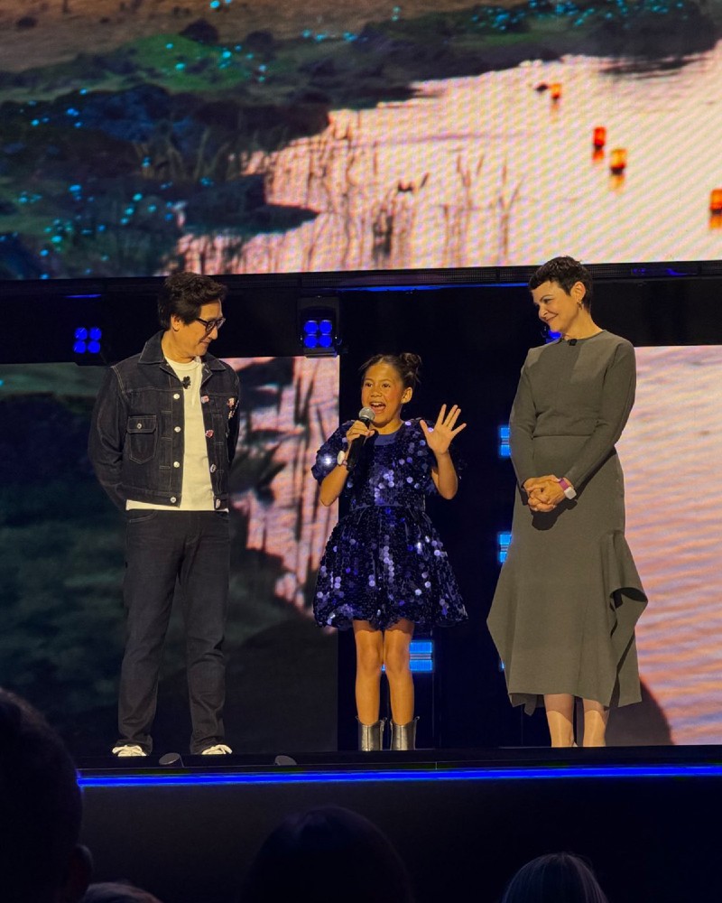 D23のステージに登場したマイア・ケアロハ(中央)。スクリーンにはスティッチとエンジェルの姿も © 2026 Disney. All Rights Reserved.